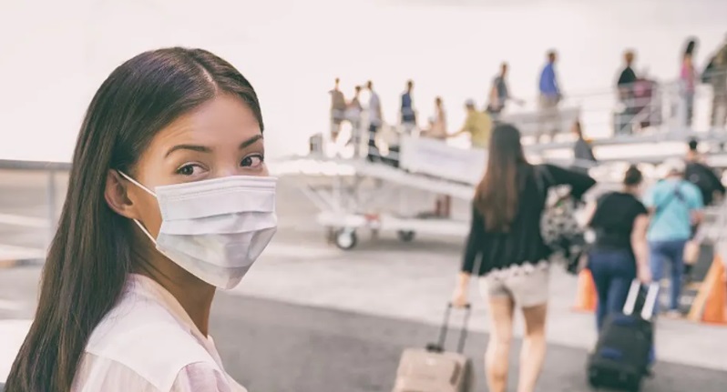 Femme avec un masque devant un avion