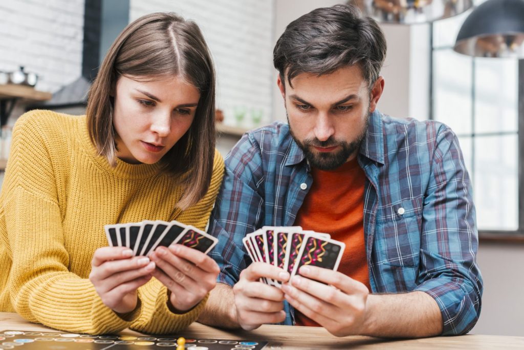 Jeune couple qui joue aux cartes